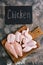 Raw chicken meat on a cutting board and a signboard with an inscription.Flat lay