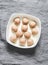 Raw chicken meatballs in a baking dish on a grey background, top view. Cooking baked meatballs