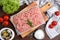 Raw chicken minced meat and ingredients on wooden table, flat lay