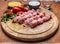 Raw chicken pieces on skewers on a chopping board with herbs vegetables sauce on wooden background close up