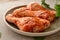 Raw chicken in a plate. Marinated meat, with oregano, herbs and paprika. Raw chicken legs, step by step cooking. Close-up, gray