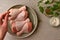 Raw chicken in a plate. Marinated meat, with oregano, herbs and paprika. Raw chicken legs, step by step cooking. Top view, gray