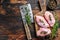 Raw Chicken skinless thigh fillet on a wooden cutting board. Black background. Top view. Copy space