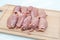 Raw chicken thigh flesh on a wooden cutting board