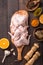 Raw chicken wings with ingredients for cooking: hohey, orange fruit, garlic, olive oil, kari  on a wooden cutting board over