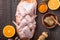 Raw chicken wings with ingredients for cooking: hohey, orange fruit, garlic, olive oil, kari  on a wooden cutting board over