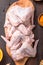 Raw chicken wings with ingredients for cooking: hohey, orange fruit, garlic, olive oil, kari  on a wooden cutting board over