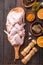 Raw chicken wings with ingredients for cooking: hohey, orange fruit, garlic, olive oil, kari  on a wooden cutting board over