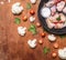 Raw chicken wings with red pepper and salt pans, cast iron with tomatoes and cauliflower on rusti? wooden background top view clo