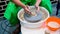 A raw clay pot in the hands of a potter. Workshop in the pottery workshop