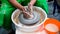 A raw clay pot in the hands of a potter. Workshop in the pottery workshop