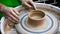 A raw clay pot in the hands of a potter. Workshop in the pottery workshop