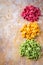 Raw colored pasta on the kitchen wooden table