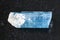 raw crystal of aquamarine (blue beryl) gem on dark