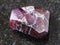 raw crystal of red garnet gemstone on dark