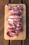 Raw cuting pieces of pork on wooden background. Piece of fresh boneless pork, neck part or collar. Big piece of red raw meat on a