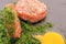 Raw cutlet for hamburger in chopped dill.