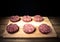 Raw cutlet of minced meat on a wooden cutting board on black background. Toned