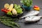 Raw dorado fish on metal grill grate. Frying pan with Brussels sprouts