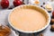 Raw dough and ingredients for traditional English apple pie on light grey table, closeup