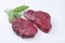 Raw dry aged bison beef rump steak slices with herbs on white background