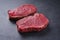 Raw dry aged bison beef rump steaks on black background