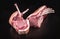 Raw dry aged tomahawk pork steak sliced on a black board