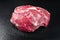 Raw dry aged wagyu beef round steak piece on black background with copy space