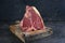 Raw dry aged wagyu porterhouse beef steak on rustic wooden board