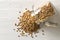 Raw, dry, uncooked brown lentil legumes in glass storage jar on white wood table background flat lay top view from above