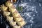 Raw dumpling with potatoes. Preparation dumplings on a wooden board on dark background. Top views with clear space