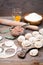 Raw dumplings on the cutting board and ingredients for their preparation: flour, egg, minced meat