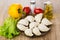 Raw dumplings in plate, lettuce, tomatoes, sweet pepper and oil