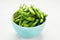 Raw edamame soya beans with salt and sauce on light gray background