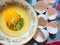 Raw egg yolk and white in a plate ready to cook. Broken crashed eggshells in the background. Closeup