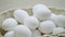 Raw eggs in a rotating basket. White chicken eggs in turn top view