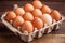 Raw eggs in rustic packaging, set against a wooden background with copy space