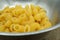 Raw elbow Macaroni Gomiti Pasta in stainless steel bowl on wooden table, Close up.