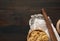 Raw fettuccine pasta, wooden rolling pin on a brown wooden board, top view