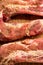 Raw fillets of pork meat freshly seasoned on top of a wooden kitchen board close up shot