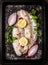 Raw fish with spices,herb,half onion,lemon and salt on dark backing tray background