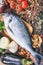 Raw fish on wooden background. Fresh, healthy uncooked whole silver color fish on wood cutting board