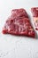 Raw Flap meat, London Broil organic meat cut side view close up over white concrete background vertical selective focus