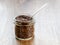 Raw flax seeds in a glass jar with metal spoon on a wooden table. Healthy food for lower cholesterol and preventing heart diseases