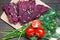 Raw foods. Dry vegan bread loaves from beet and walnut on kitchen board on wooden table