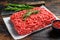 Raw forcemeat beef, ground meat on butcher paper. Dark wooden background. Top view