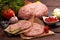 Raw forcemeat with Raw burger cutlet from pork meat on a slate stone plate on a wooden background