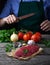 Raw fresh beef steak, vegetable and womens hands with knife