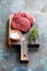 Raw fresh beef two steaks meat, sea salt and fresh thyme on a wooden cutting board