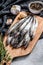 Raw fresh capelin fish on cutting board. Gray background. Top view